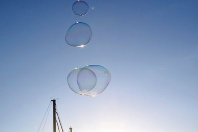 Low angle view of bubbles against rainbow in sky