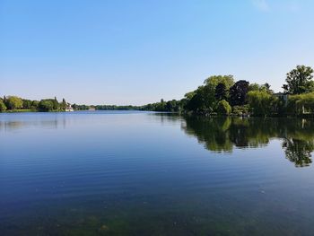 Scenic view of lake against clear blue sky