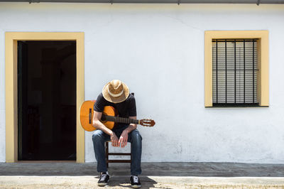 Full length of man playing on window of building
