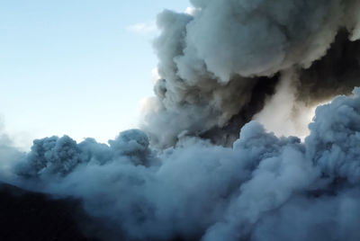 Smoke emitting from volcanic mountain against sky