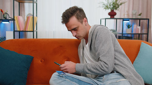 Young man doing online shopping at home