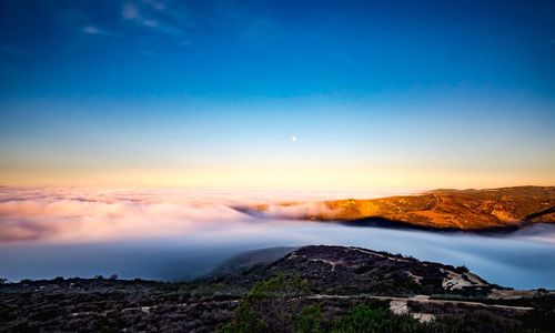 Scenic view of sea and mountains against clear sky