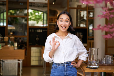 Portrait of young woman standing in cafe