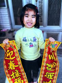 Portrait of smiling girl holding paper with text