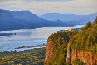 Scenic view of sea and mountains against sky