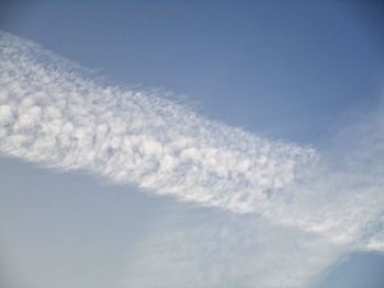 Low angle view of vapor trail in blue sky