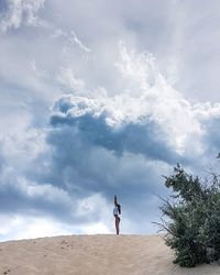 Woman exercising on sand dune