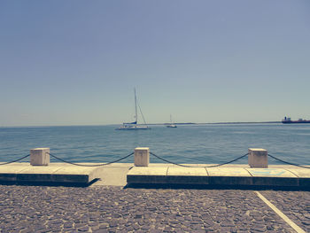 Sailboats on sea against clear sky