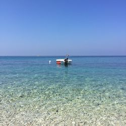 Boats on sea against clear sky