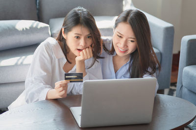 Two women sitting on laptop