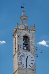 Low angle view of clock tower against blue sky