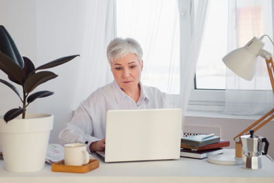 Young woman using laptop at home