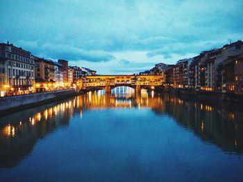 Illuminated bridge over river at night