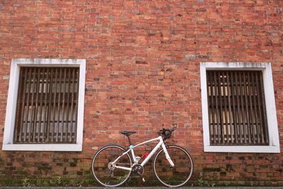Bicycle leaning against brick wall