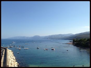 Boats in sea against clear sky