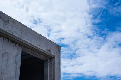 Low angle view of building against cloudy sky