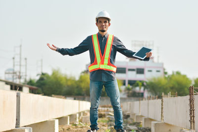 Portrait of young man standing against built structure