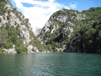 Scenic view of sea and mountains against sky