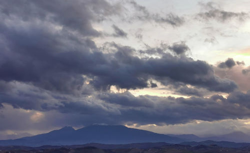 Low angle view of mountains against dramatic sky