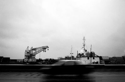 Cranes at commercial dock against sky