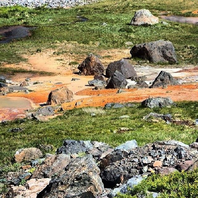 grass, rock - object, landscape, nature, tranquility, rock formation, rock, tranquil scene, field, scenics, high angle view, beauty in nature, non-urban scene, stream, stone, day, geology, mountain, outdoors, no people