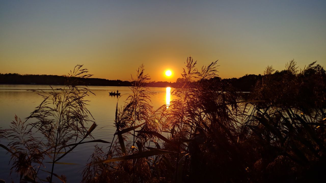 sky, sunset, water, beauty in nature, scenics - nature, tranquility, tranquil scene, sun, reflection, plant, nature, lake, silhouette, orange color, no people, non-urban scene, sunlight, idyllic, tree, outdoors