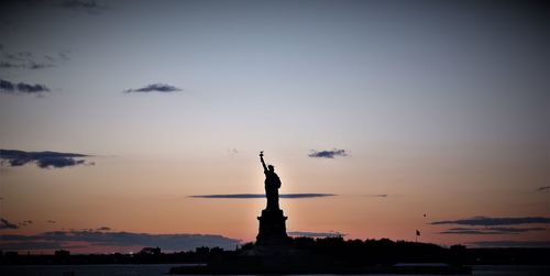 Silhouette of statue of liberty at sunset