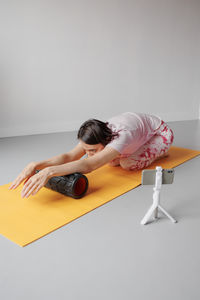 Portrait of young woman exercising against white background