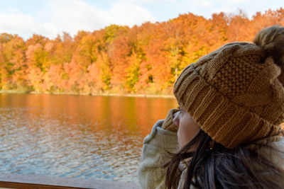 Rear view of woman standing by lake