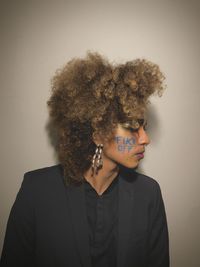 Portrait of young man standing against wall