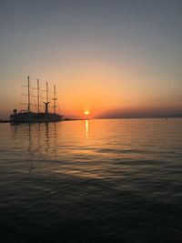 Sailboats in sea against sky during sunset