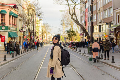 Portrait of woman walking on road in city