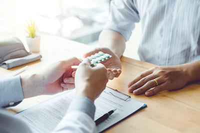 Close-up of man holding hands on table