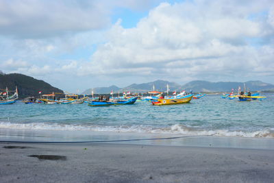 Boats moored on beach against sky