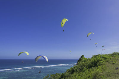 People flying over sea against sky