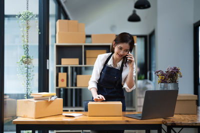 Young woman using laptop while sitting on table