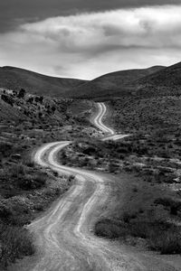 Road passing through landscape against sky