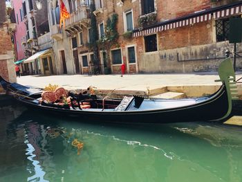 Boats moored in canal in city