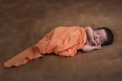 High angle view of cute baby girl sleeping on bed