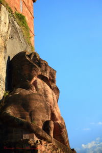 Low angle view of rock formation against clear blue sky