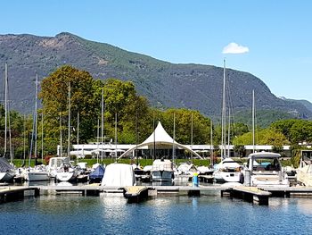 Sailboats moored in lake against sky