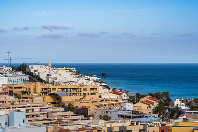 High angle view of townscape by sea against sky