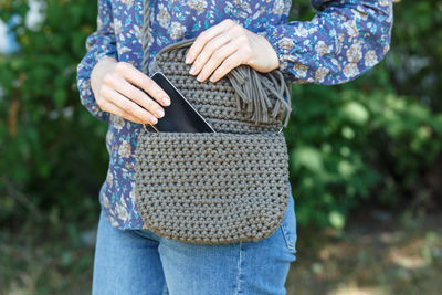 Midsection of woman removing mobile phone from purse