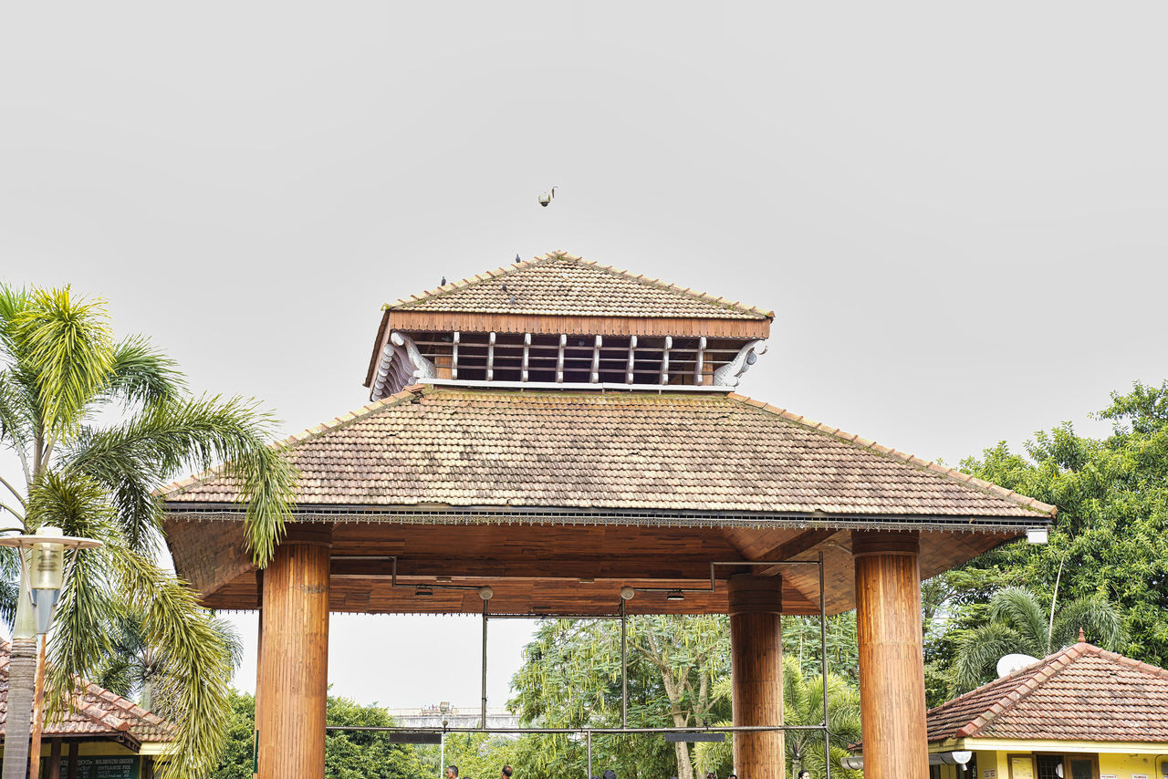 architecture, built structure, building exterior, roof, tree, plant, building, sky, day, no people, nature, house, residential district, outdoors, wood - material, clear sky, low angle view, roof tile, copy space, palm tree