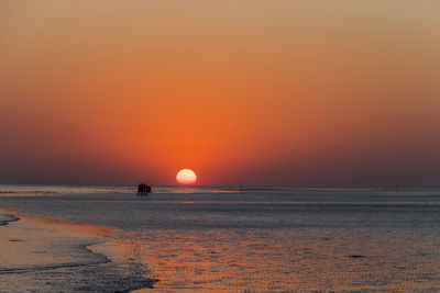 Scenic view of sea against orange sky