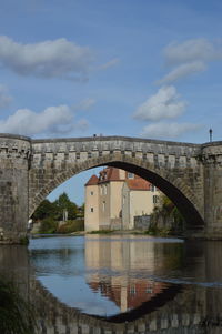 Arch bridge over river against sky