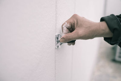 Cropped image of house painter removing paint from wall