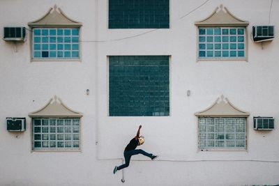 Man jumping against building