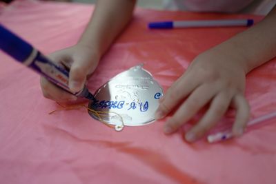 High angle view of hands writing over decoration with pen