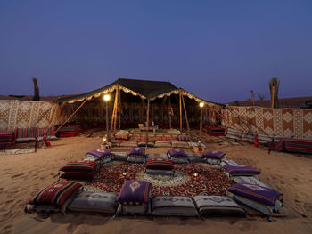 Pillows with carpets arranged by tent at desert during dusk